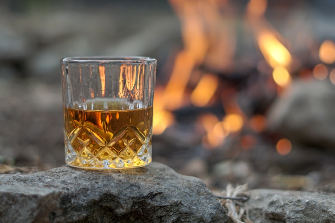 services-02 Vintage crystal glass of bourbon whiskey by an outdoor campfire
